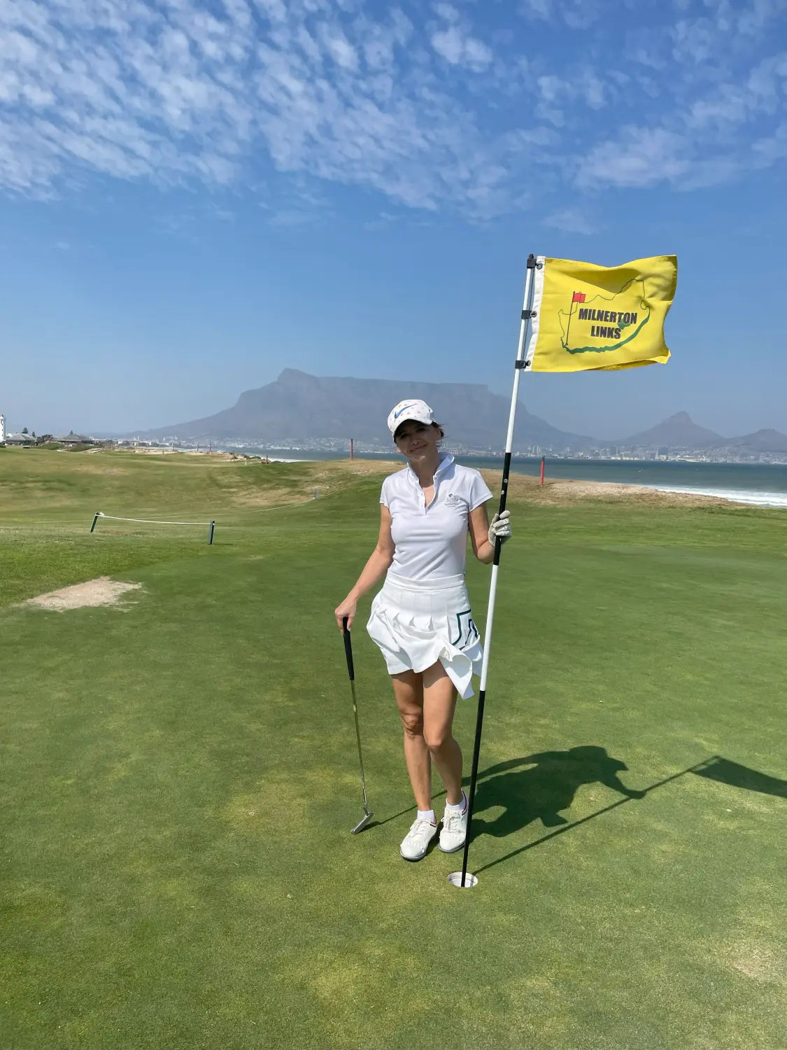 A woman holding golf flag at Kelly Golf